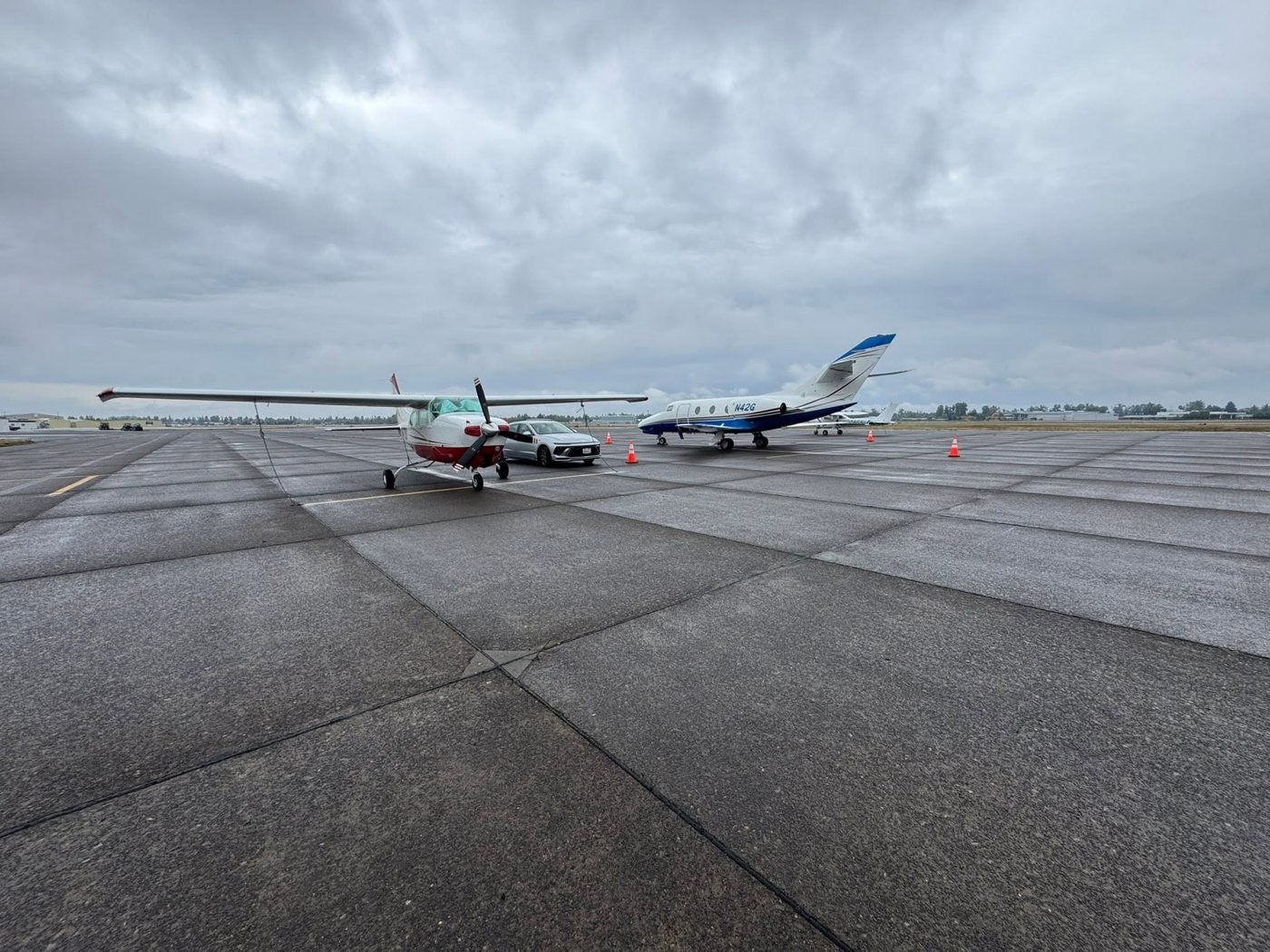 Airplanes parked on a wide ramp under clouds
