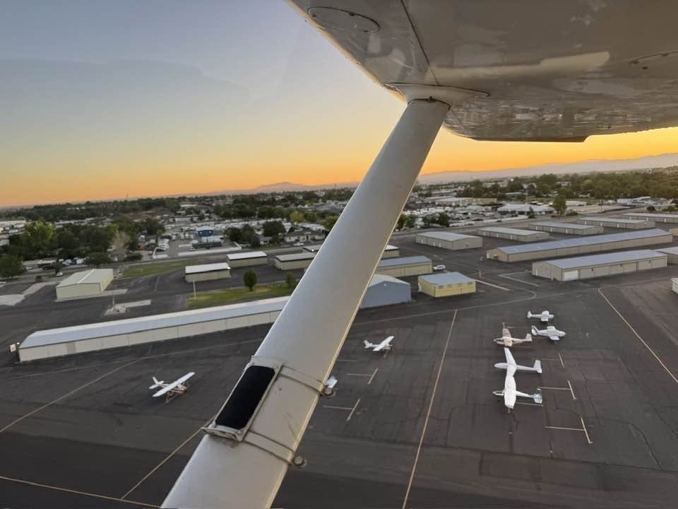 Wing strut over an airport ramp lined with hangars